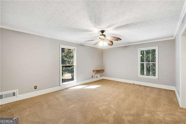 carpeted spare room featuring ceiling fan, crown molding, and a textured ceiling