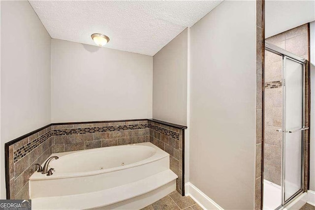 bathroom with plus walk in shower, tile patterned flooring, and a textured ceiling