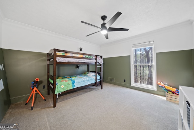 carpeted bedroom featuring ceiling fan, crown molding, and a textured ceiling