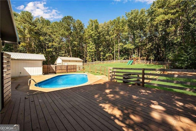 view of swimming pool with a playground and a wooden deck