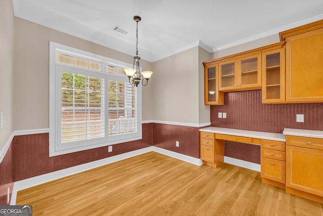 kitchen with light hardwood / wood-style flooring, pendant lighting, a chandelier, built in desk, and ornamental molding