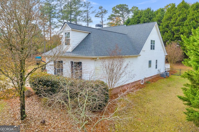 view of side of home featuring a lawn and cooling unit