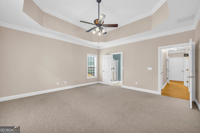 unfurnished bedroom featuring light colored carpet, ceiling fan, a raised ceiling, and ornamental molding