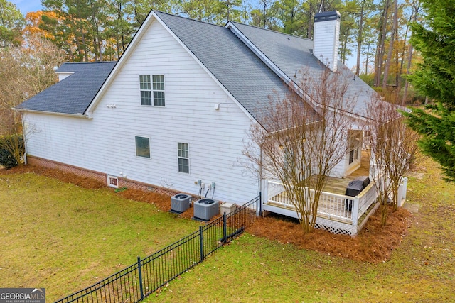 exterior space with a deck, a yard, and central AC