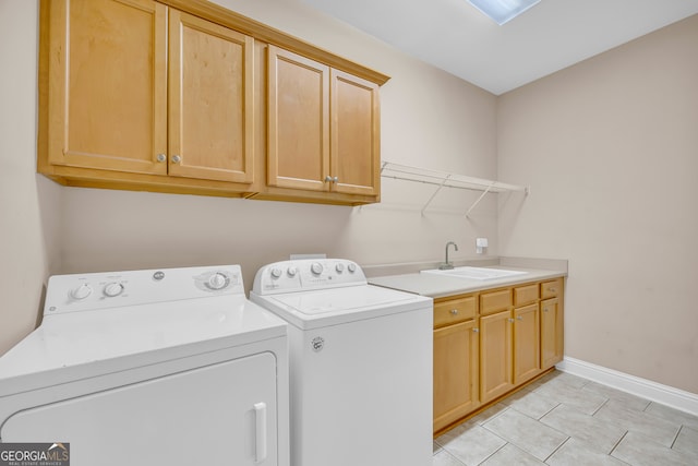 washroom with cabinets, light tile patterned flooring, washer and clothes dryer, and sink