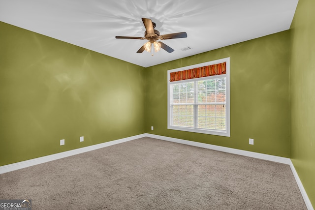 empty room featuring ceiling fan and carpet