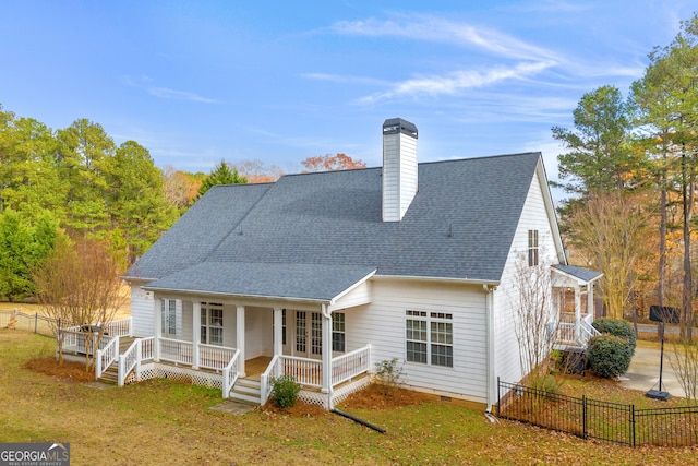 rear view of property with covered porch, french doors, and a lawn