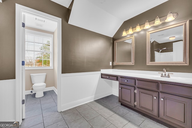 bathroom featuring tile patterned floors, vanity, lofted ceiling, and toilet