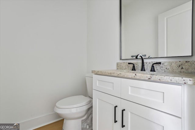 bathroom featuring vanity, wood-type flooring, and toilet