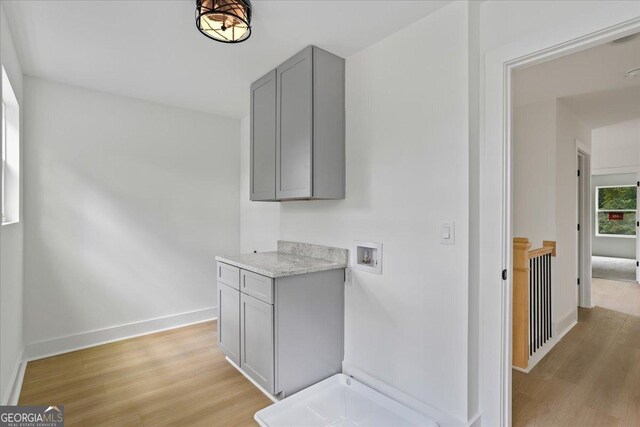 interior space featuring gray cabinetry, light stone counters, and light hardwood / wood-style floors