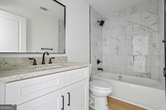 full bathroom with vanity, toilet, tiled shower / bath combo, and wood-type flooring