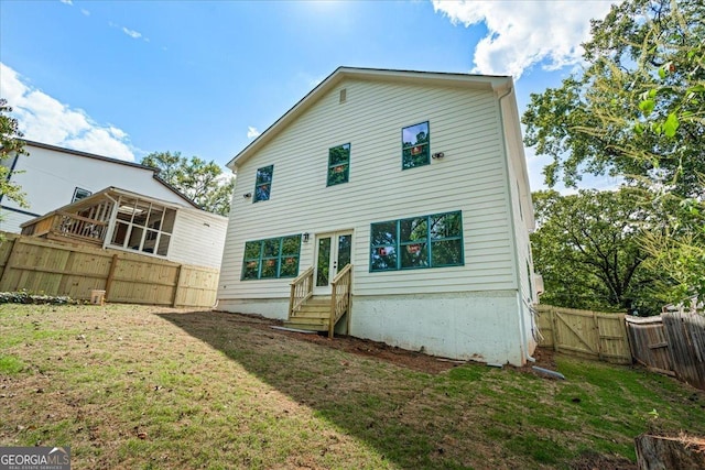 back of house with a lawn