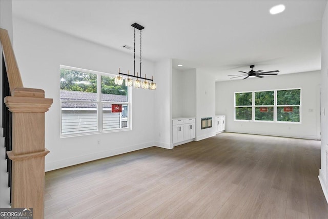 unfurnished living room with ceiling fan and light wood-type flooring