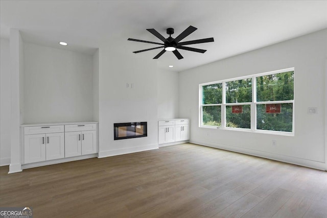 unfurnished living room with ceiling fan and hardwood / wood-style floors