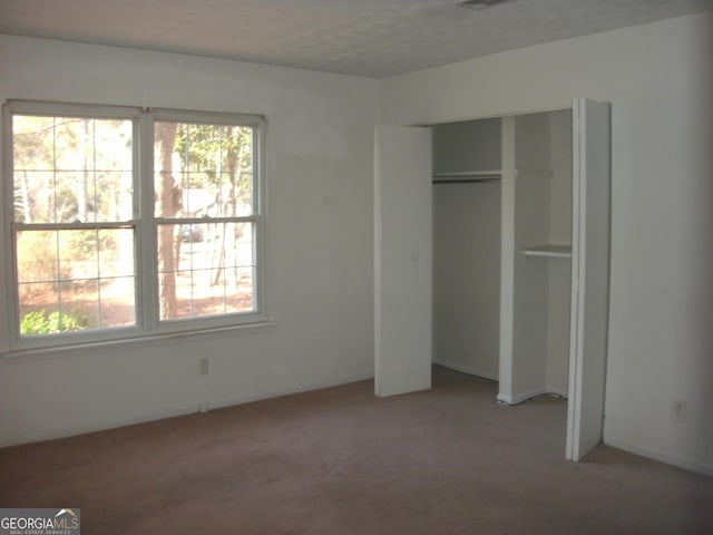 unfurnished bedroom featuring a closet and light carpet