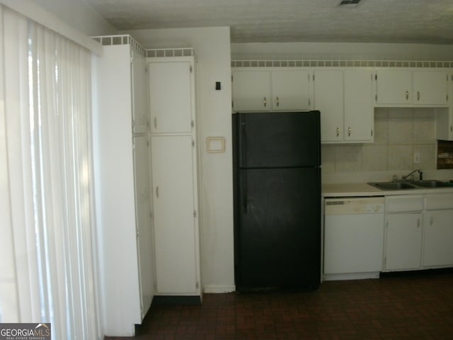 kitchen featuring white cabinetry, tasteful backsplash, black fridge, white dishwasher, and sink