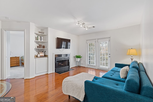 living room featuring a premium fireplace and hardwood / wood-style floors