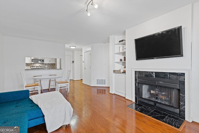 living room featuring a tile fireplace and light hardwood / wood-style flooring