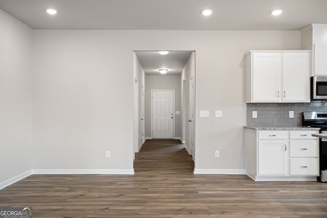 kitchen featuring range, backsplash, white cabinetry, and hardwood / wood-style floors