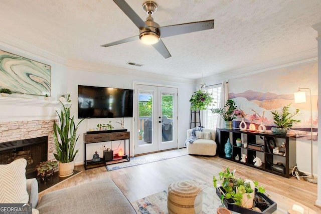 living room with hardwood / wood-style flooring, ornamental molding, a textured ceiling, and french doors