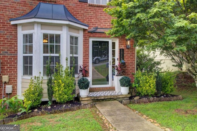 doorway to property with a lawn