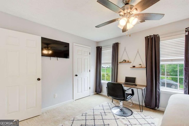 carpeted office space with ceiling fan