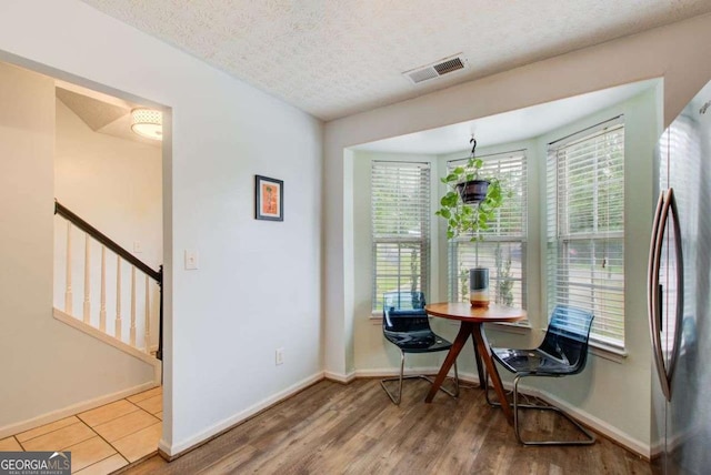 dining room featuring a textured ceiling and hardwood / wood-style flooring