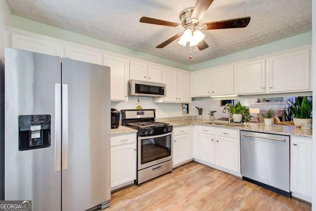 kitchen featuring a textured ceiling, sink, white cabinetry, and stainless steel appliances