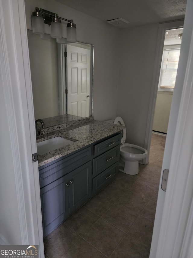 bathroom with tile patterned floors, vanity, and toilet