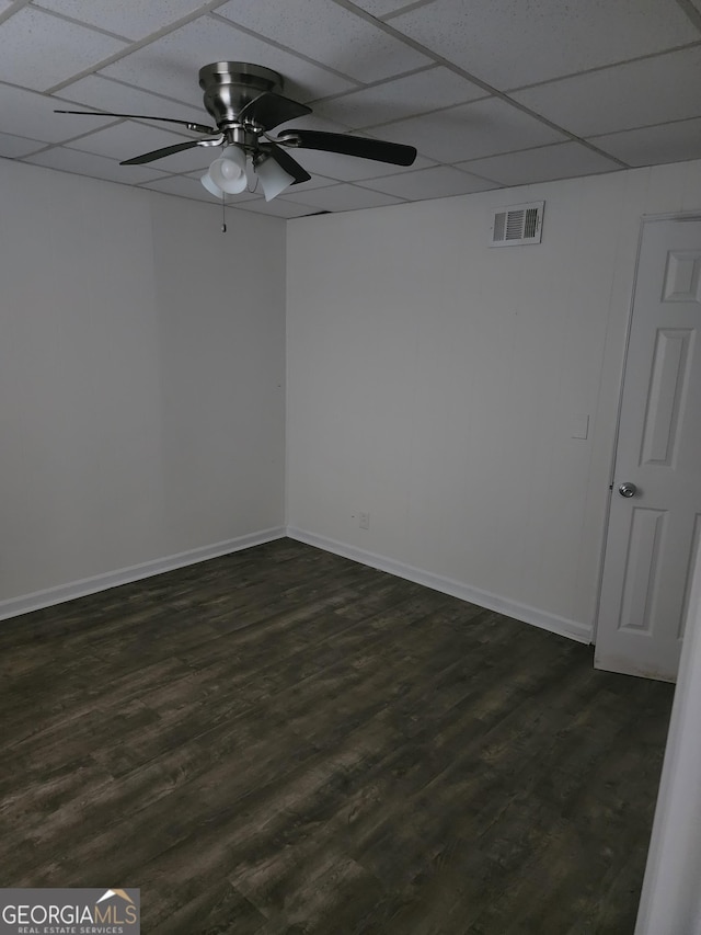 unfurnished room featuring a drop ceiling, dark wood-type flooring, and ceiling fan