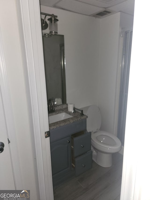 bathroom featuring hardwood / wood-style floors, vanity, toilet, and a shower with shower door