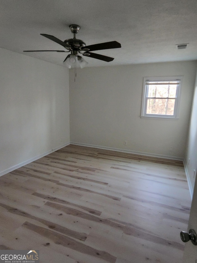 spare room with ceiling fan, a textured ceiling, and light hardwood / wood-style flooring