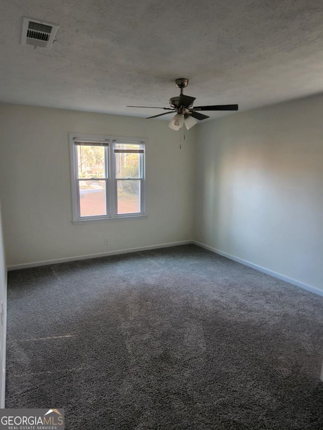 carpeted spare room featuring ceiling fan and a textured ceiling