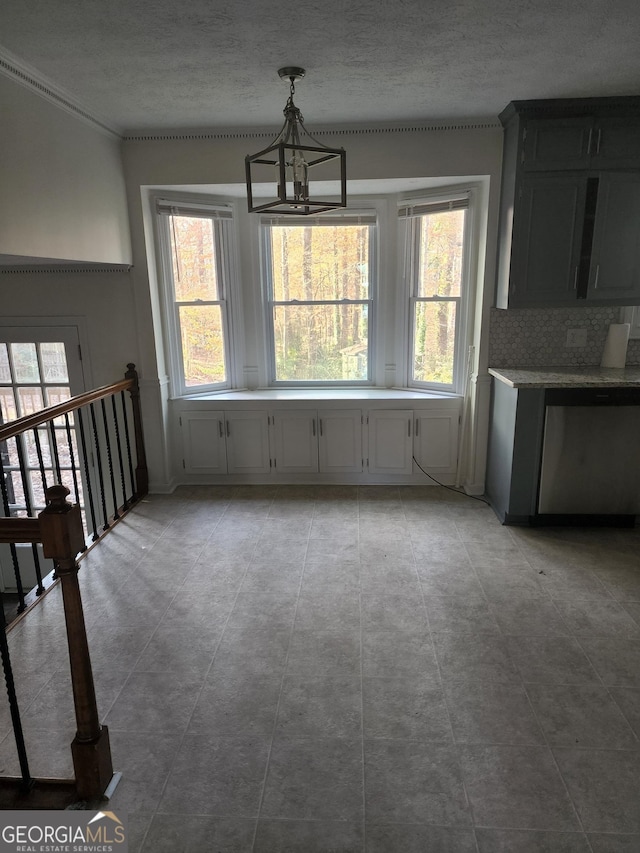 unfurnished dining area featuring light tile patterned floors, a textured ceiling, and an inviting chandelier