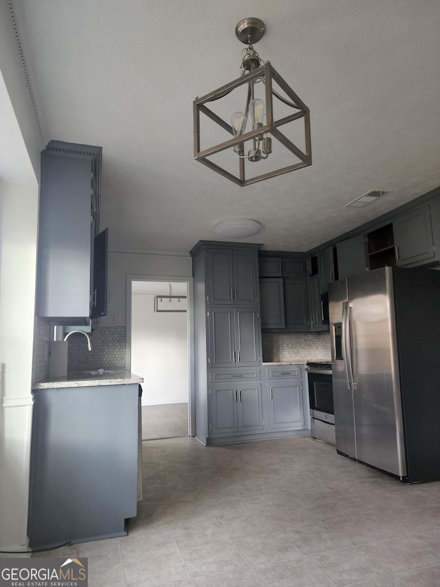 kitchen with decorative light fixtures, sink, stainless steel appliances, and tasteful backsplash