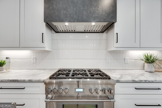 kitchen featuring white cabinetry, high end range, and wall chimney range hood