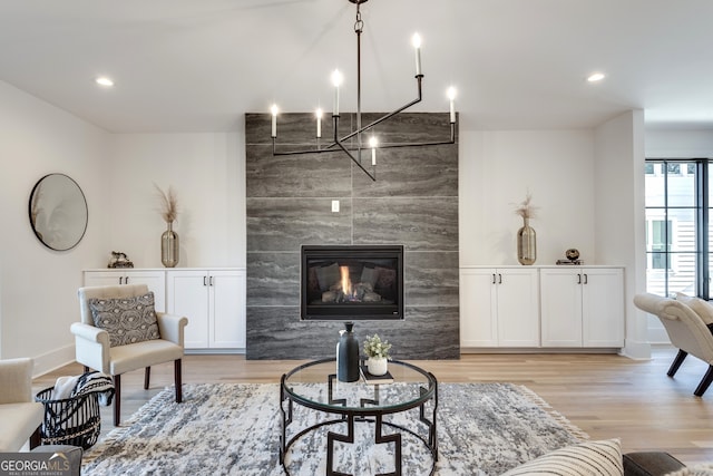 living room with a tile fireplace and light wood-type flooring