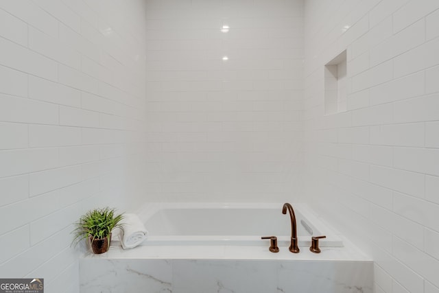 bathroom featuring a relaxing tiled tub