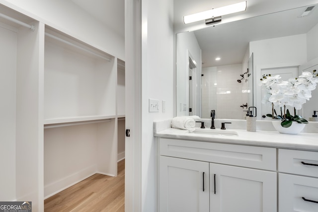 bathroom featuring hardwood / wood-style floors, vanity, and a shower with door