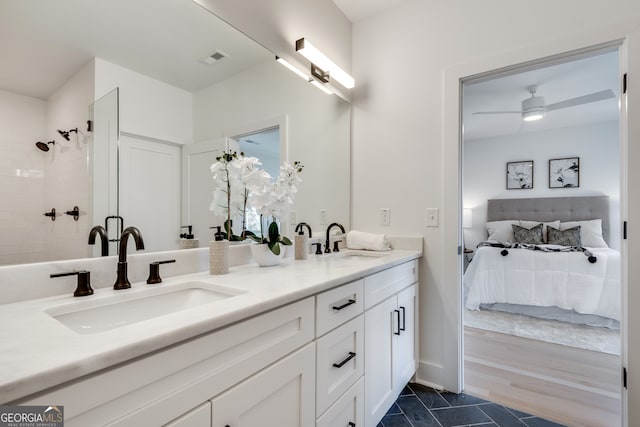 bathroom featuring ceiling fan, a tile shower, and vanity