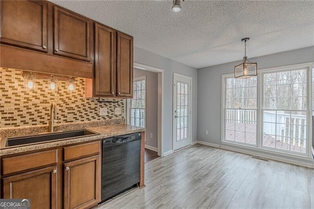 kitchen with plenty of natural light, sink, light wood-type flooring, and black dishwasher