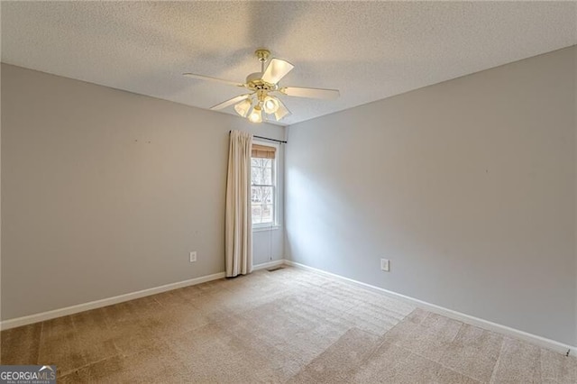 carpeted spare room featuring ceiling fan and a textured ceiling