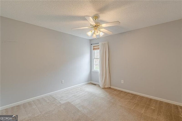 empty room with light carpet, a textured ceiling, and ceiling fan