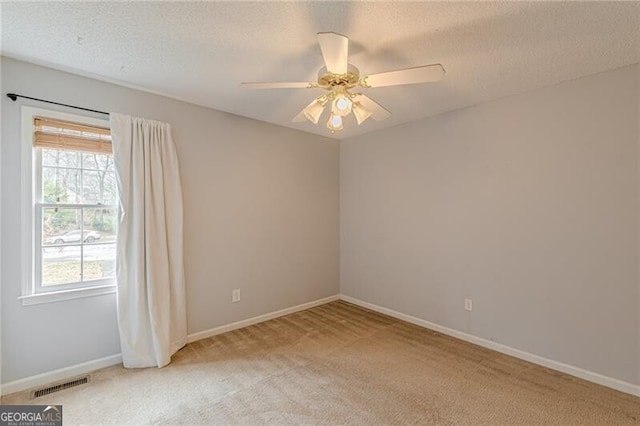 carpeted empty room with a textured ceiling and ceiling fan