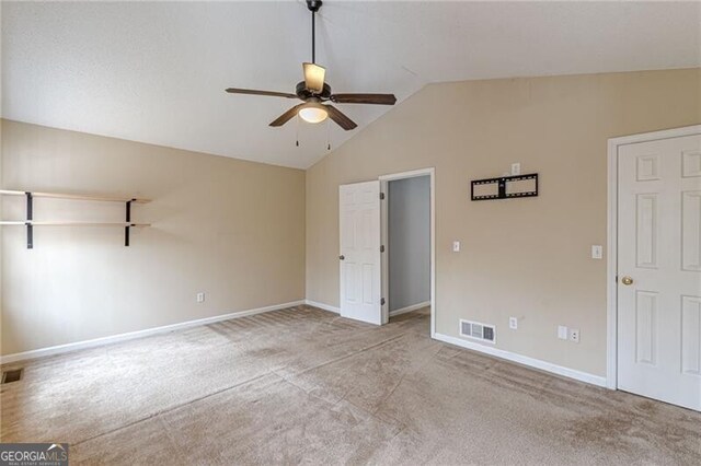 unfurnished bedroom featuring ceiling fan, light carpet, and vaulted ceiling