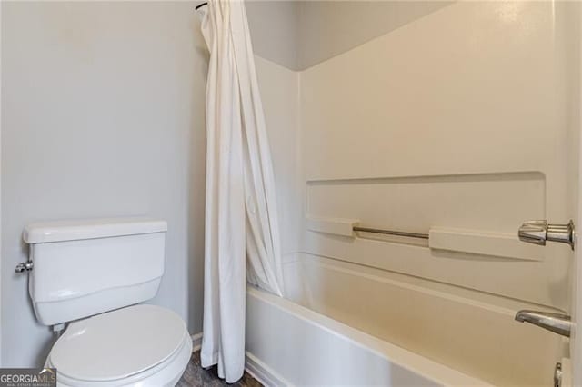 bathroom with shower / tub combo and toilet