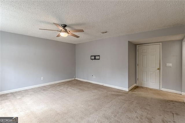 carpeted empty room featuring ceiling fan and a textured ceiling