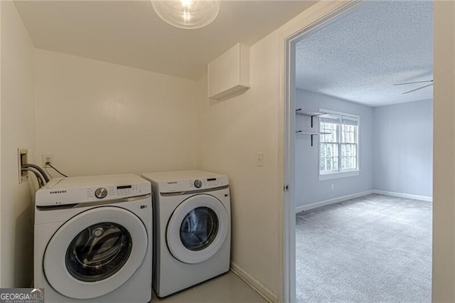 laundry room featuring separate washer and dryer, ceiling fan, light colored carpet, and a textured ceiling