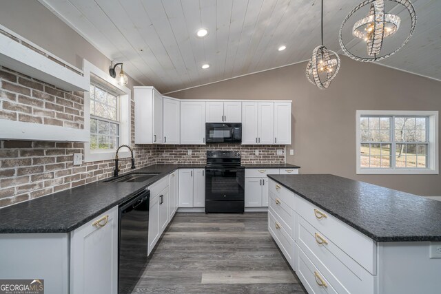 kitchen featuring lofted ceiling, decorative backsplash, a sink, dark countertops, and black appliances