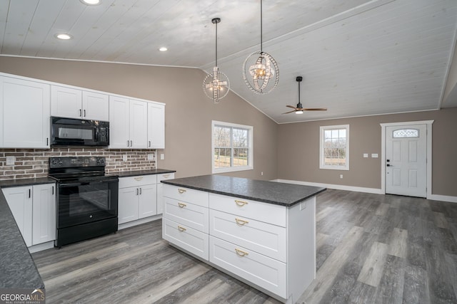 kitchen with hanging light fixtures, white cabinets, black appliances, and vaulted ceiling